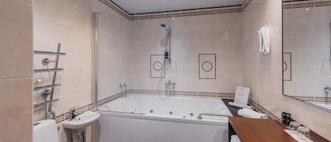 Un baño moderno con una bañera grande, un lavabo y un inodoro.