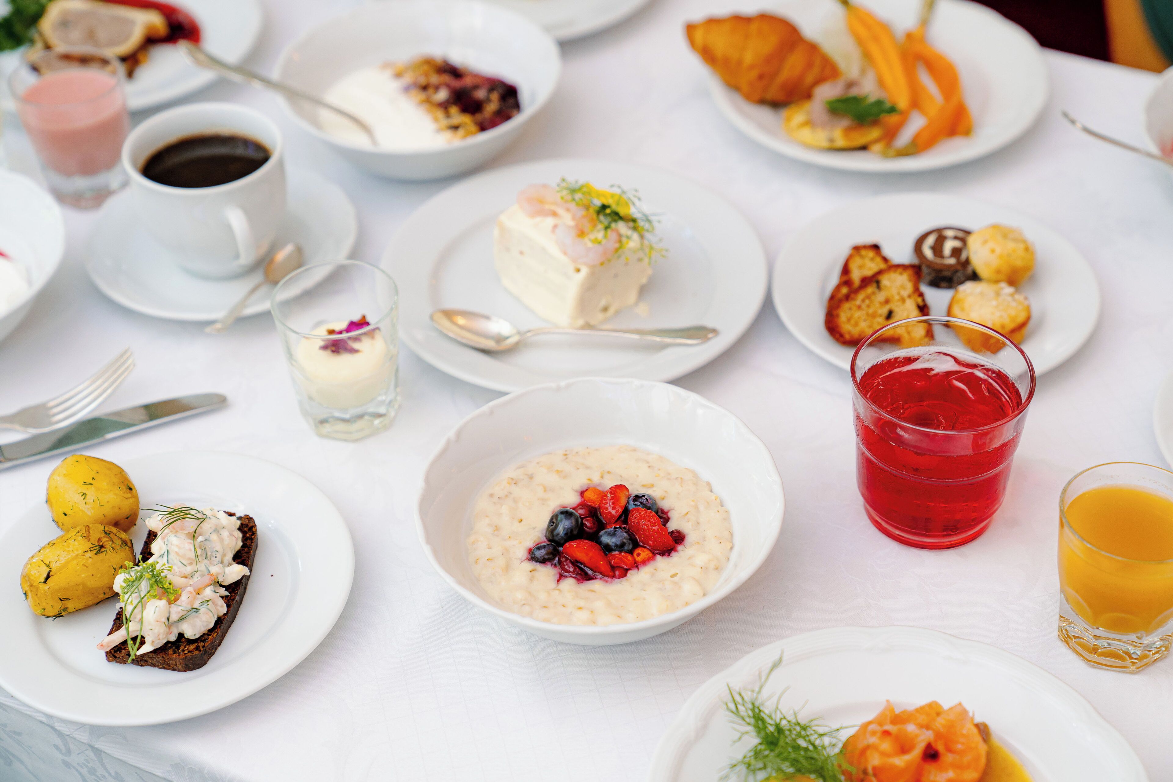A table set with various breakfast items including oatmeal, croissants, and pastries.