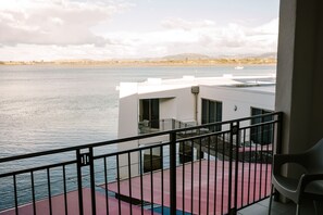 A balcony with a view of a calm body of water, a distant shoreline, and a mountain range. - Trinity Wharf Tauranga (Tauranga)