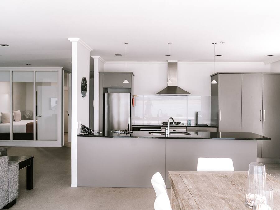 A modern kitchen with a central island, built-in appliances, and pendant lighting.