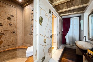 A bathroom with a mosaic wall, a wooden bench, a sink, and a mirror. - Locanda dello Spuntino (Grottaferrata)