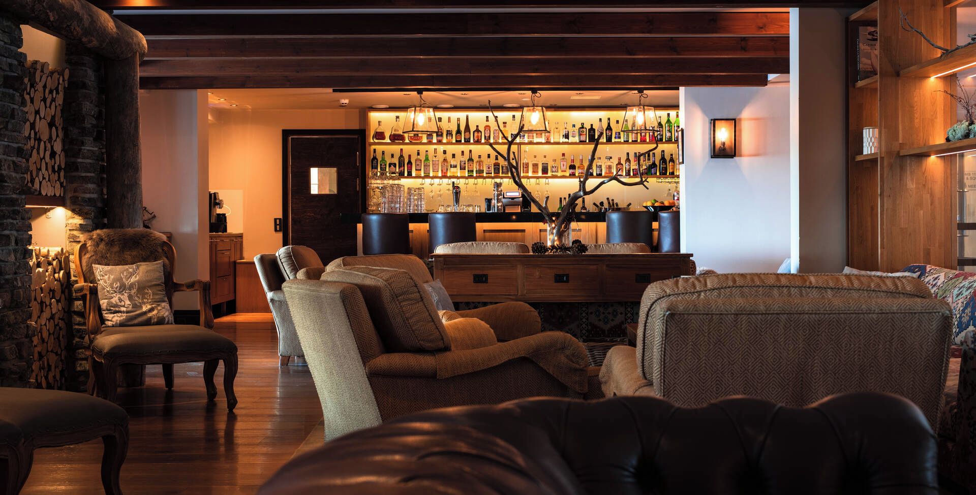Una sala de estar acogedora con una zona de bar al fondo, que ofrece diversas opciones de asientos y una chimenea.