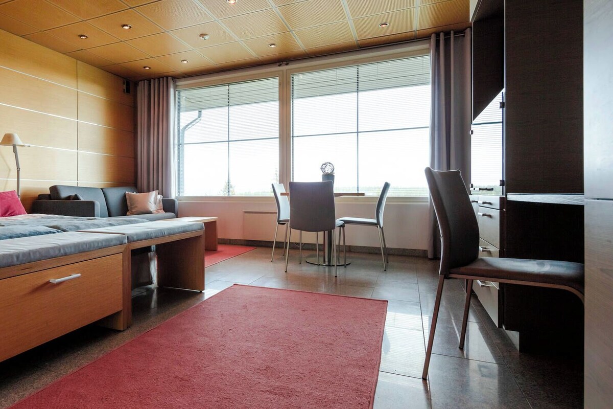 Una habitación de hotel moderna con una cama grande, un escritorio y una silla.