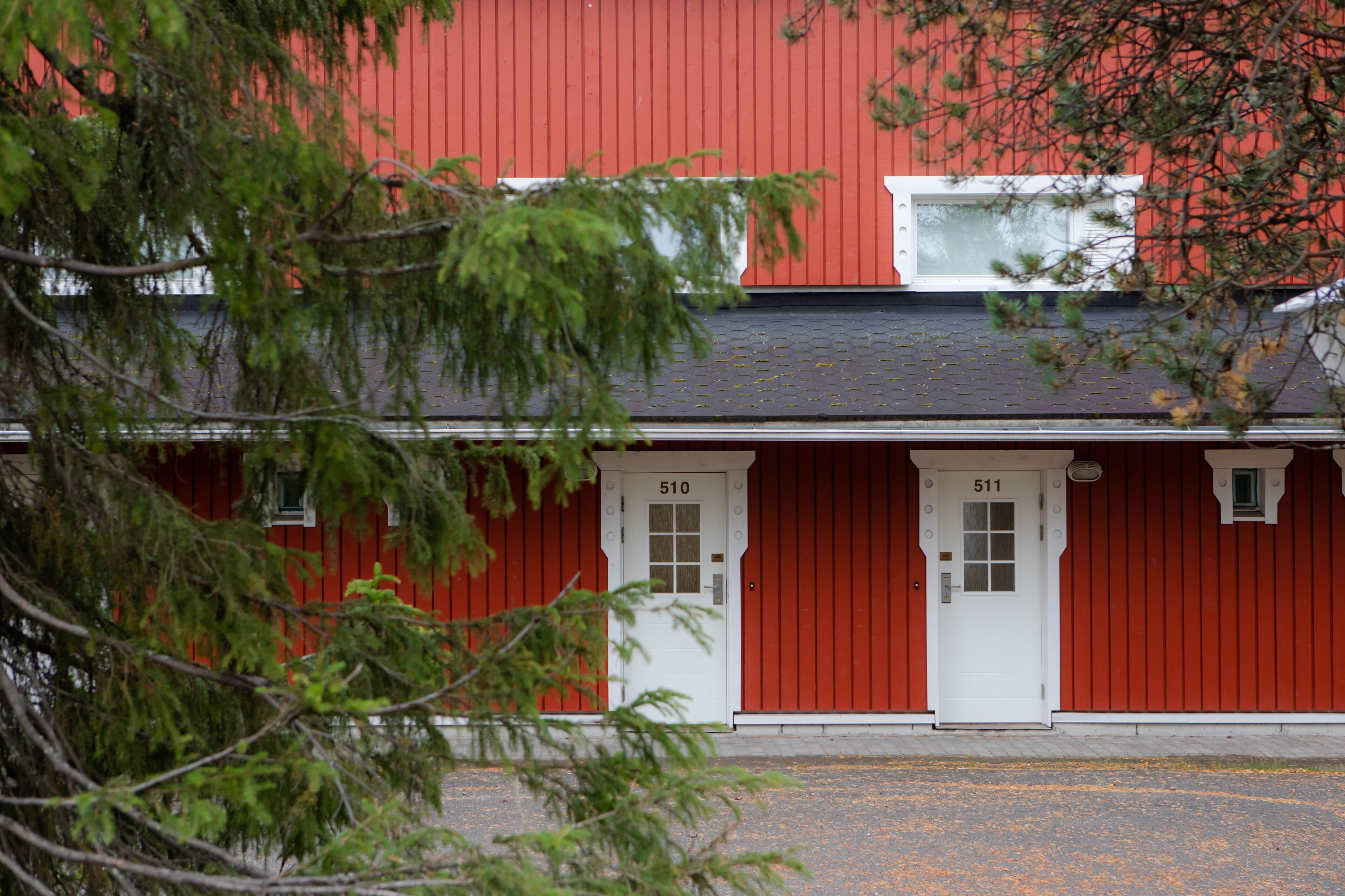 Un bâtiment rouge avec deux portes blanches portant les numéros 510 et 511.