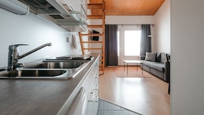 Une cuisine moderne dotée d’appareils électroménagers en acier inoxydable et d’un plafond en bois.