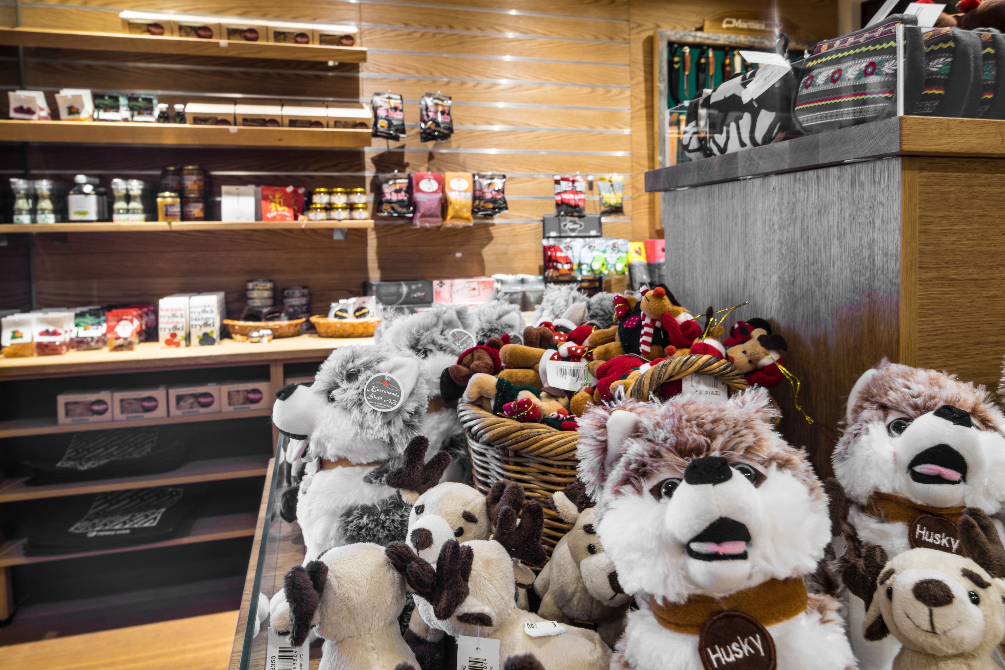 A store with shelves stocked with various packaged goods and a display of stuffed animals.