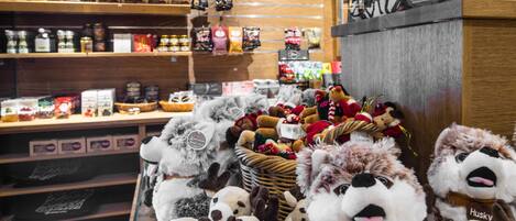 A store with shelves stocked with various packaged goods and a display of stuffed animals.