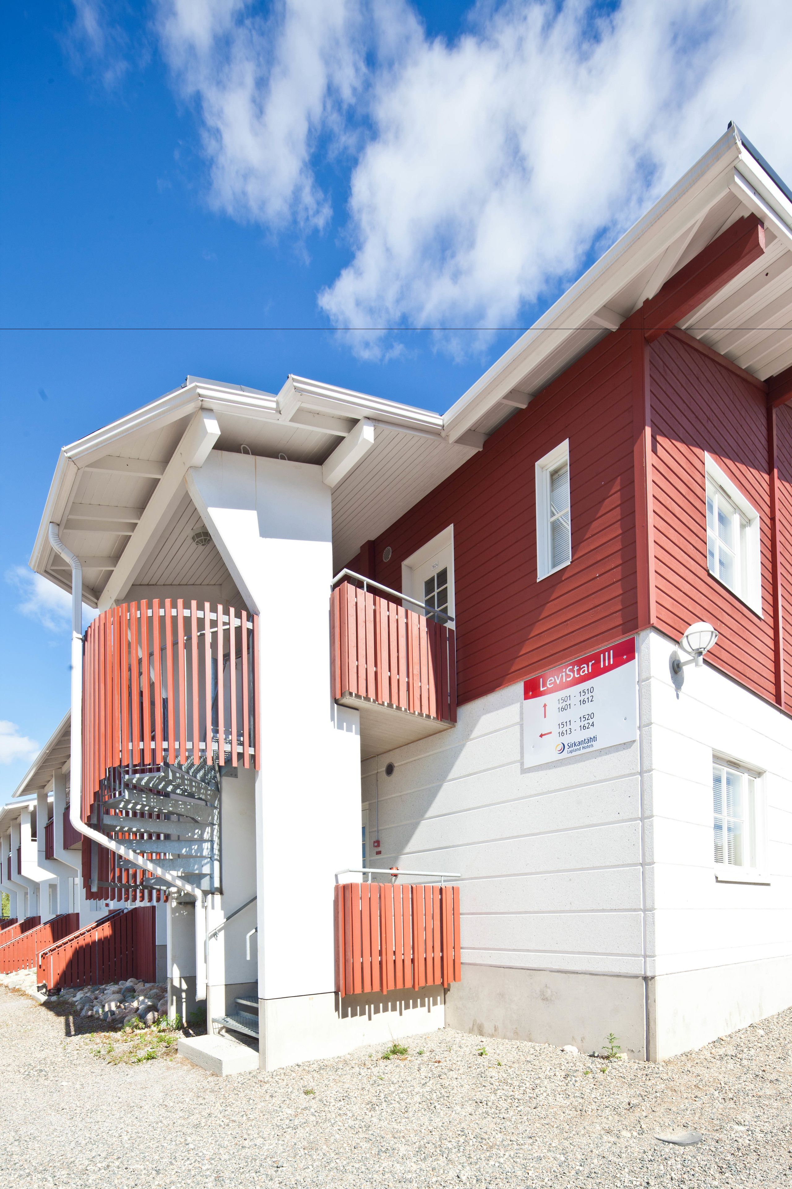 Punavalkoinen rakennus, jossa on kyltti, jossa lukee »Levitast III», ja portaat, jotka johtavat ylempään kerrokseen.