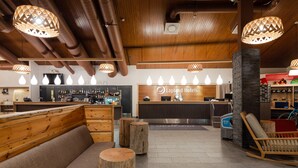 A hotel lobby with wooden benches and a reception desk.