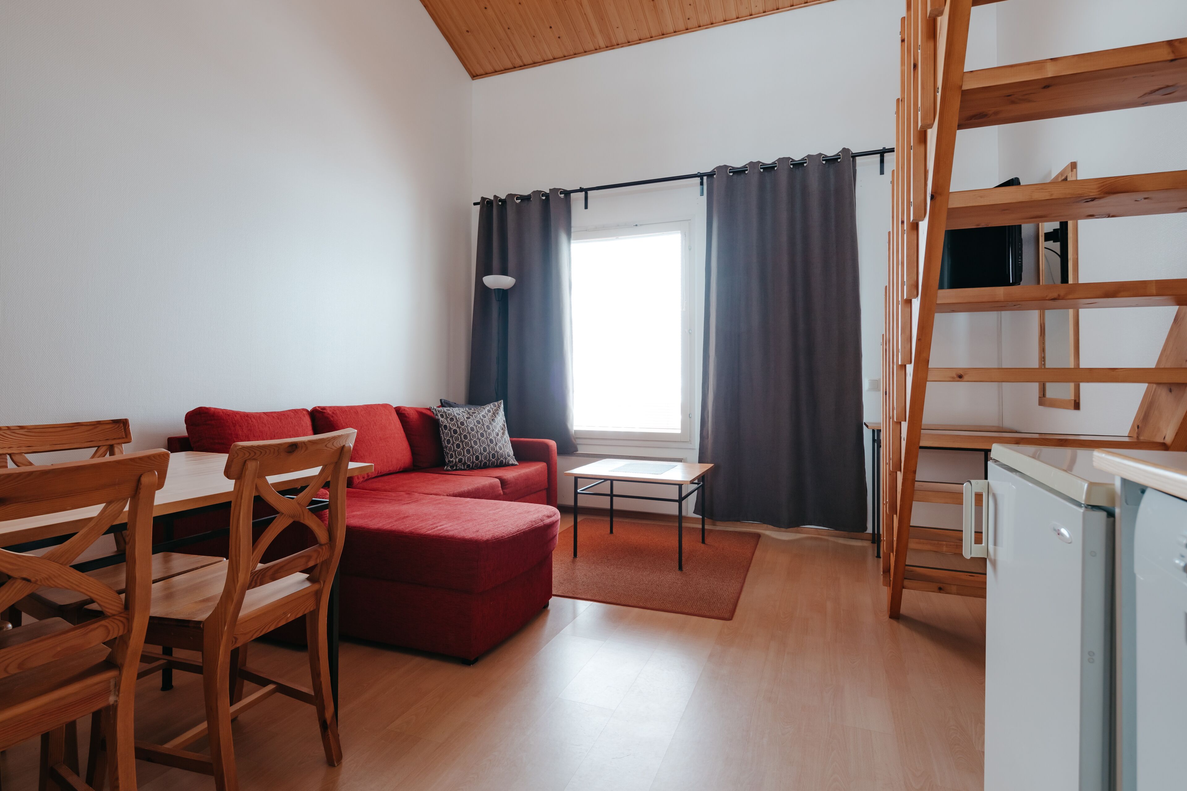 A compact living space with a dining area, a sofa, a small table, and a kitchenette.
