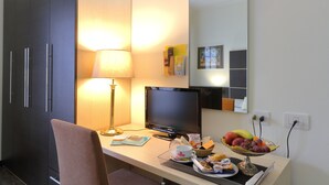 A hotel room with a desk, a lamp, a computer, and a fruit bowl. - Hotel Ferrari (Chiavari)