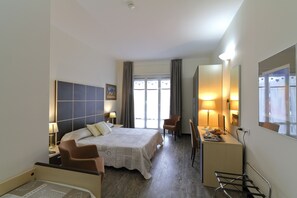 A hotel room with a bed, two chairs, a desk, and a large mirror. - Hotel Ferrari (Chiavari)