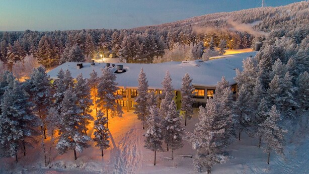 A snow-covered lodge with a large central building surrounded by trees. - Lapland Hotels Hetta (Enontekio)