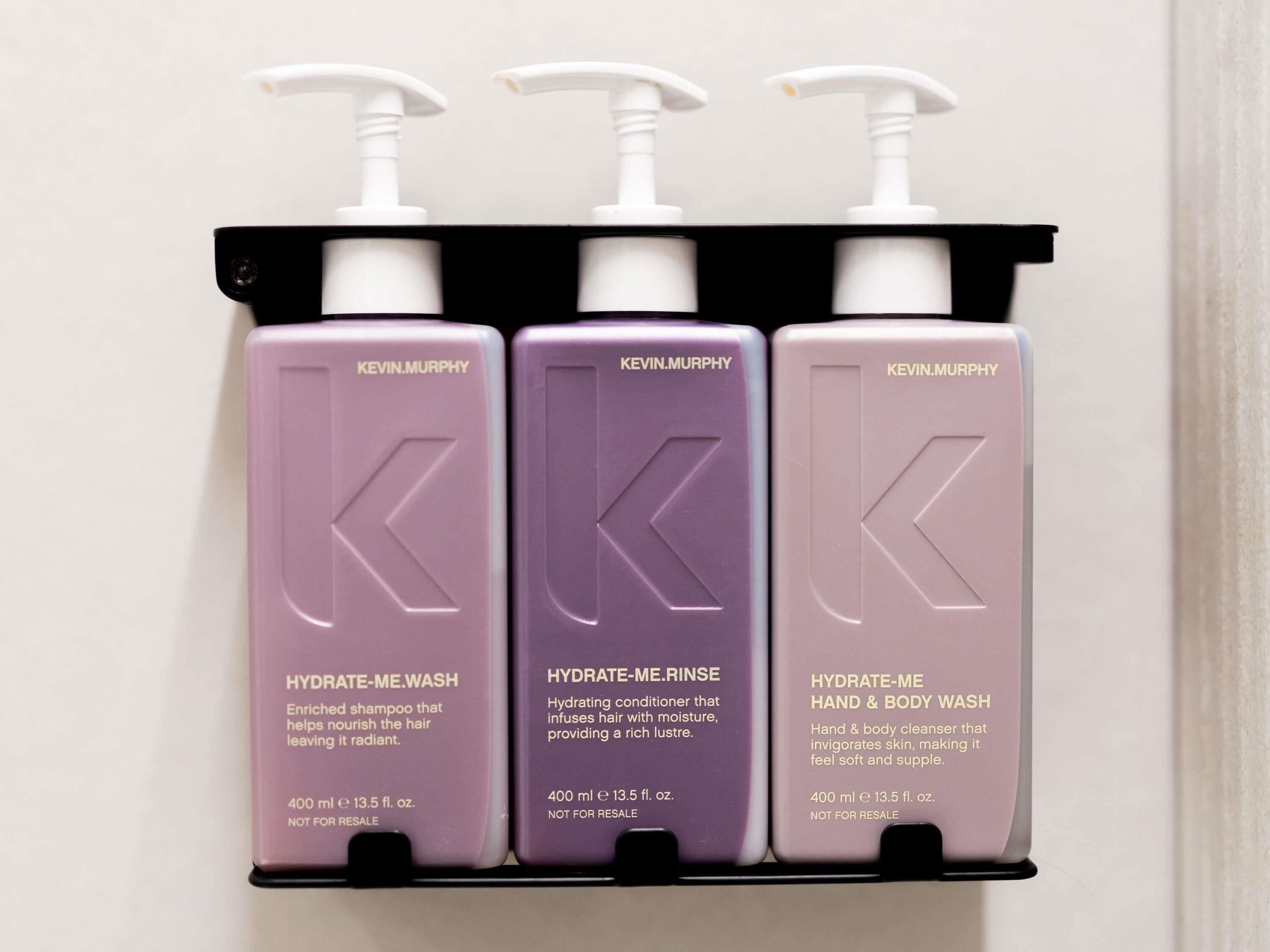 Tre flasker Kevin Murphy hudplejeprodukter står på en sort hylde.