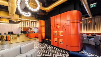 A modern lobby with a central seating area, a bar, and a shoe display.