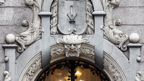 An ornate architectural entrance with a clock above a doorway, featuring intricate carvings and a decorative shield. - TRIBE Riga City Centre Hotel - Renovated 2026 (Riga)