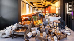 A breakfast buffet with various food items and a seating area with tables and chairs. - TRIBE Riga City Centre Hotel - Renovated 2026 (Riga)