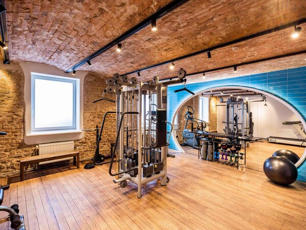 A gym with a brick ceiling, wooden floor, and various exercise equipment. - TRIBE Riga City Centre Hotel - Renovated 2026 (Riga)