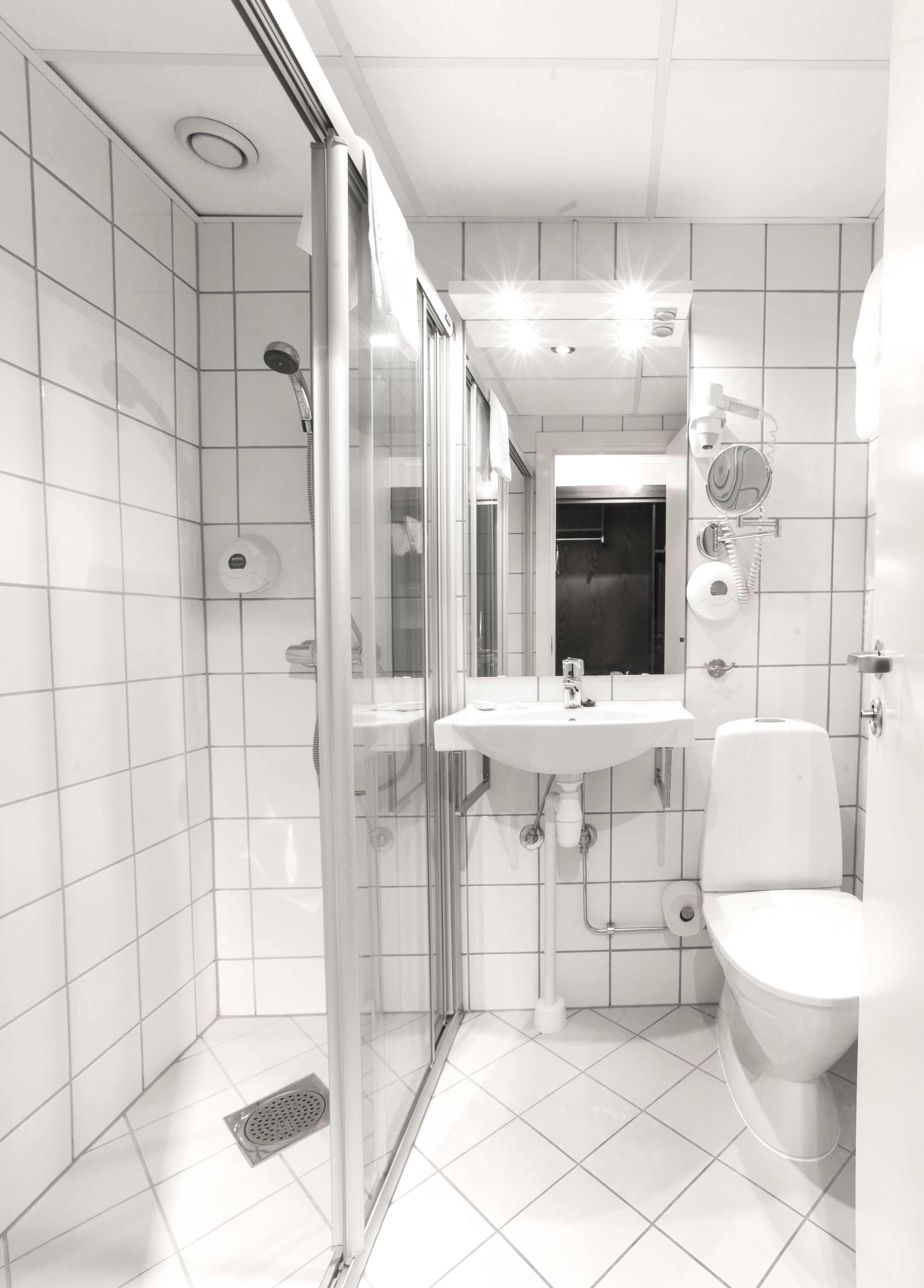 Une salle de bain moderne avec une douche à parois de verre, un lavabo blanc et des toilettes.
