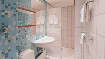 Une salle de bain moderne avec un lavabo, un miroir et un porte-serviettes.