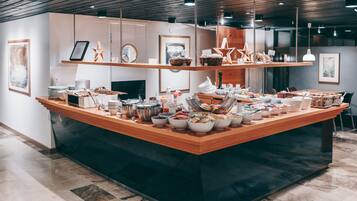 A buffet setup with various food items and utensils on a wooden counter.