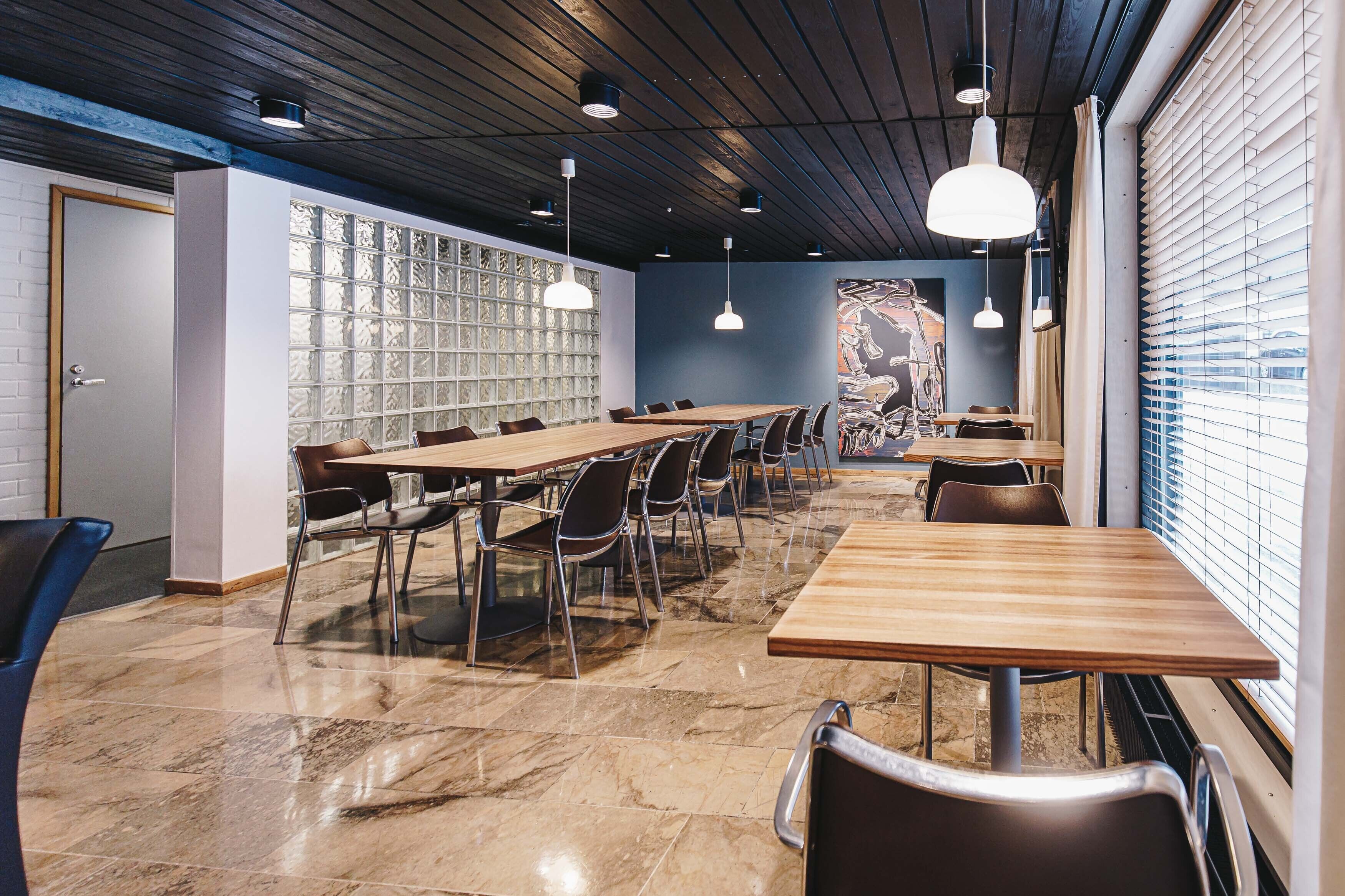 A conference room with a long table, chairs, and pendant lights.