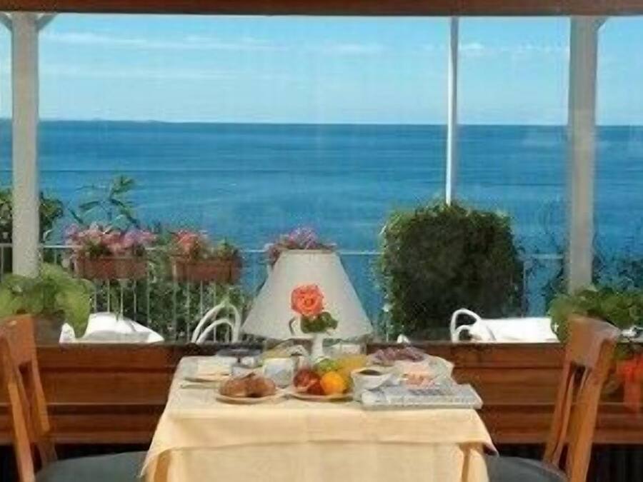 Una mesa con alimentos para el desayuno y vista al océano.
