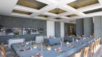 A long dining table set with chairs, a ceiling with geometric patterns, and a neutral color scheme.