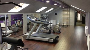 A gym with treadmills, stationary bikes, and exercise equipment.