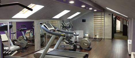 A gym with treadmills, stationary bikes, and exercise equipment.