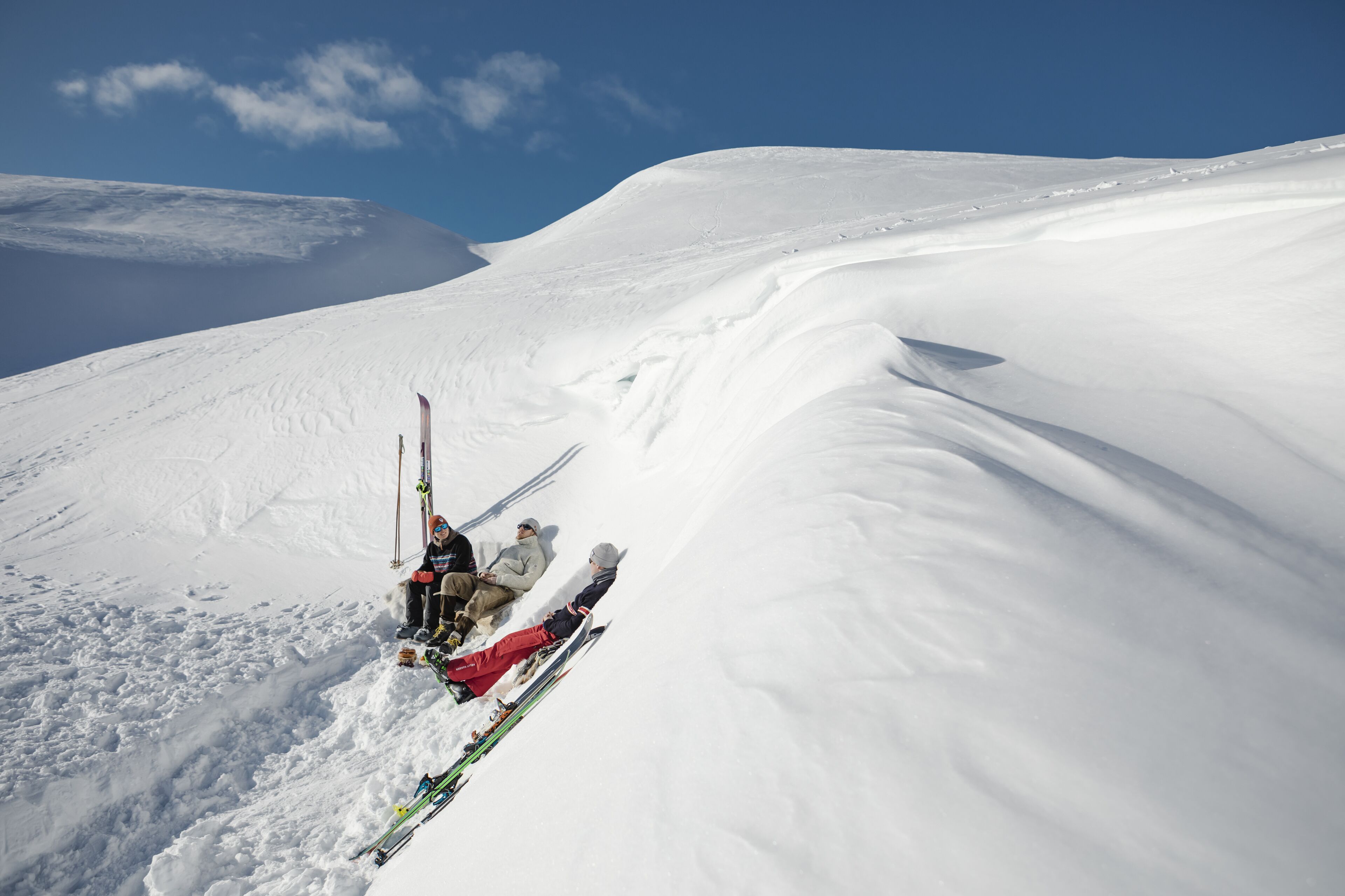 En snötäckt bergssluttning med skidåkare.