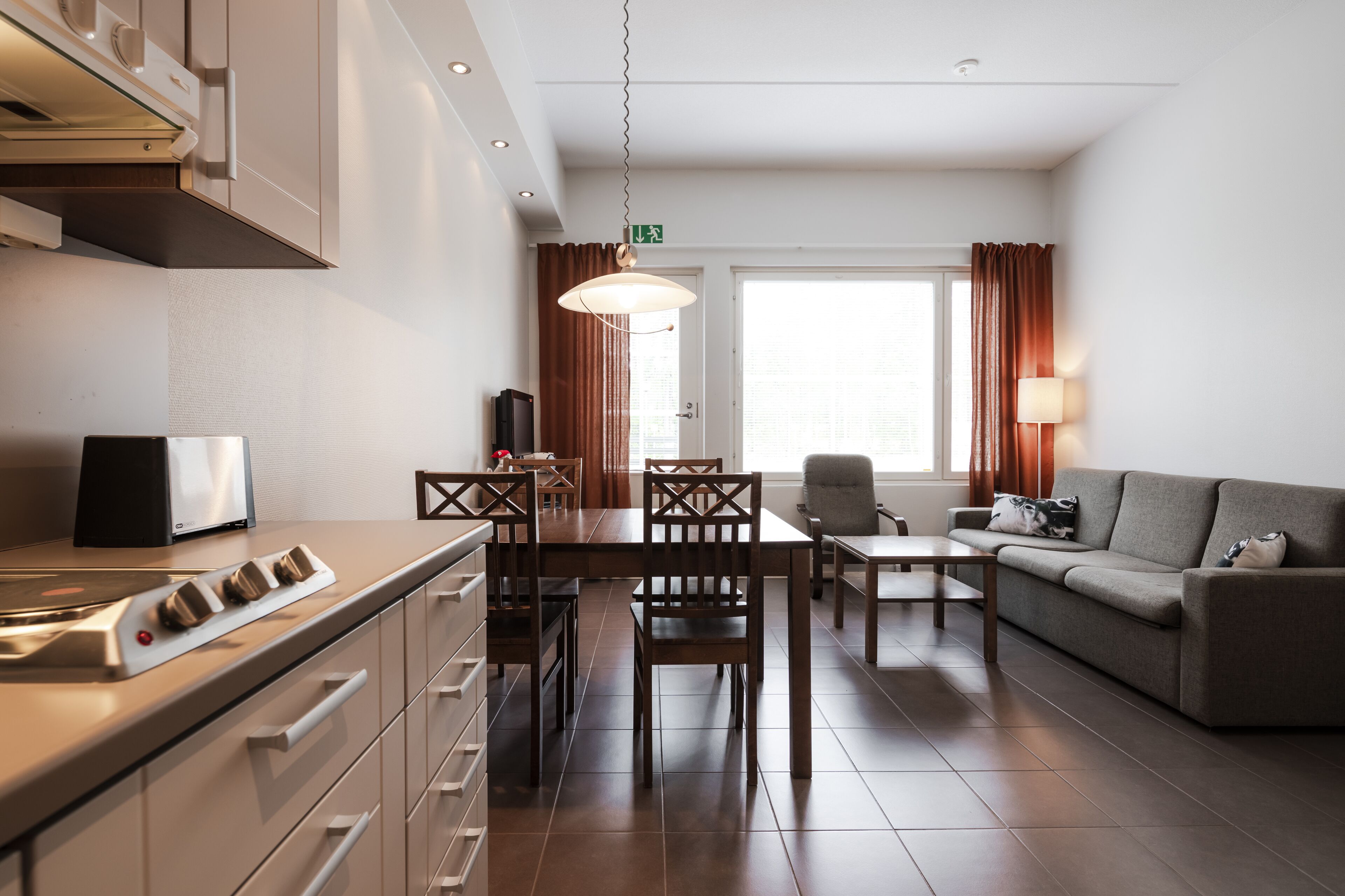 Una cocina moderna con comedor, sofá y televisor.