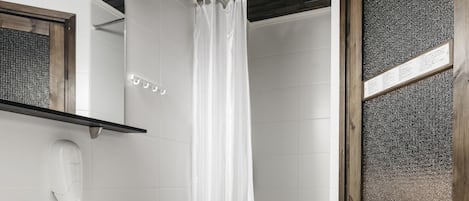 A bathroom with a white sink, a wooden door, and a shower curtain.