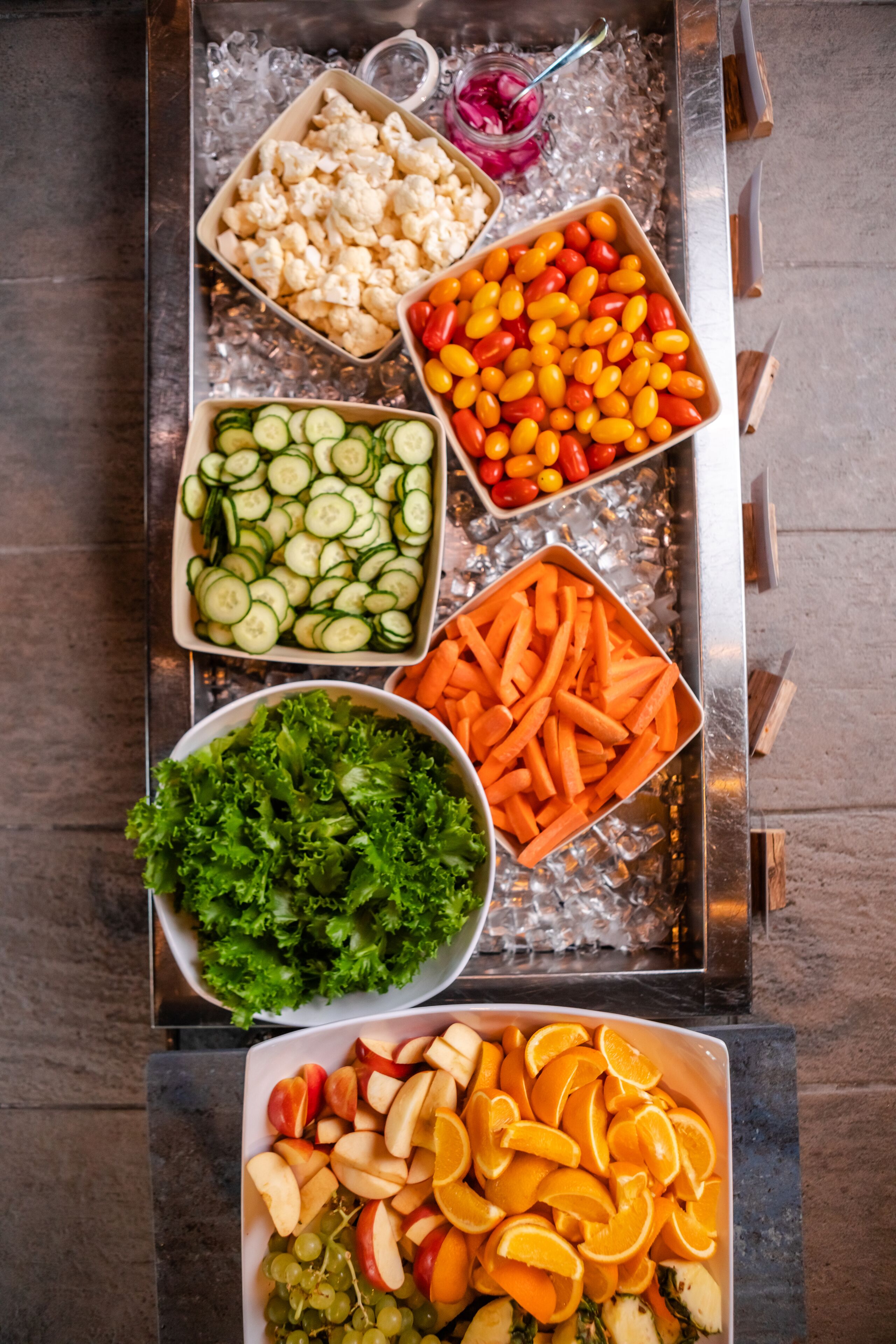 A tray with various food items including vegetables and fruits.