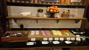 A buffet setup with various food items and utensils. - Hotel Bishops Arms Lund (Lund)