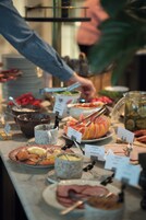 Una mesa de buffet con diversos alimentos y utensilios.