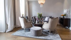 A modern living room with a sofa set, two armchairs, a coffee table, and a chandelier. - Continental du Sud (Ystad)