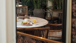 A dining area with a round table, chairs, and a large mirror reflecting the interior. - Continental du Sud (Ystad)