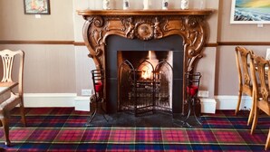 A room with a fireplace, a plaid carpet, and two chairs. - The Elgin Kintore Arms, Inverurie (Inverurie)