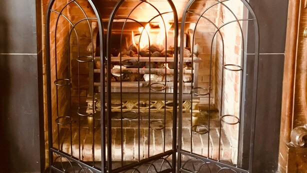 A fireplace with a decorative mantel and a metal screen. - The Elgin Kintore Arms, Inverurie (Inverurie)