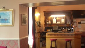 A bar area with stools, a counter, and a mirror. There is a framed picture on the wall and a window with curtains. - The Elgin Kintore Arms, Inverurie (Inverurie)