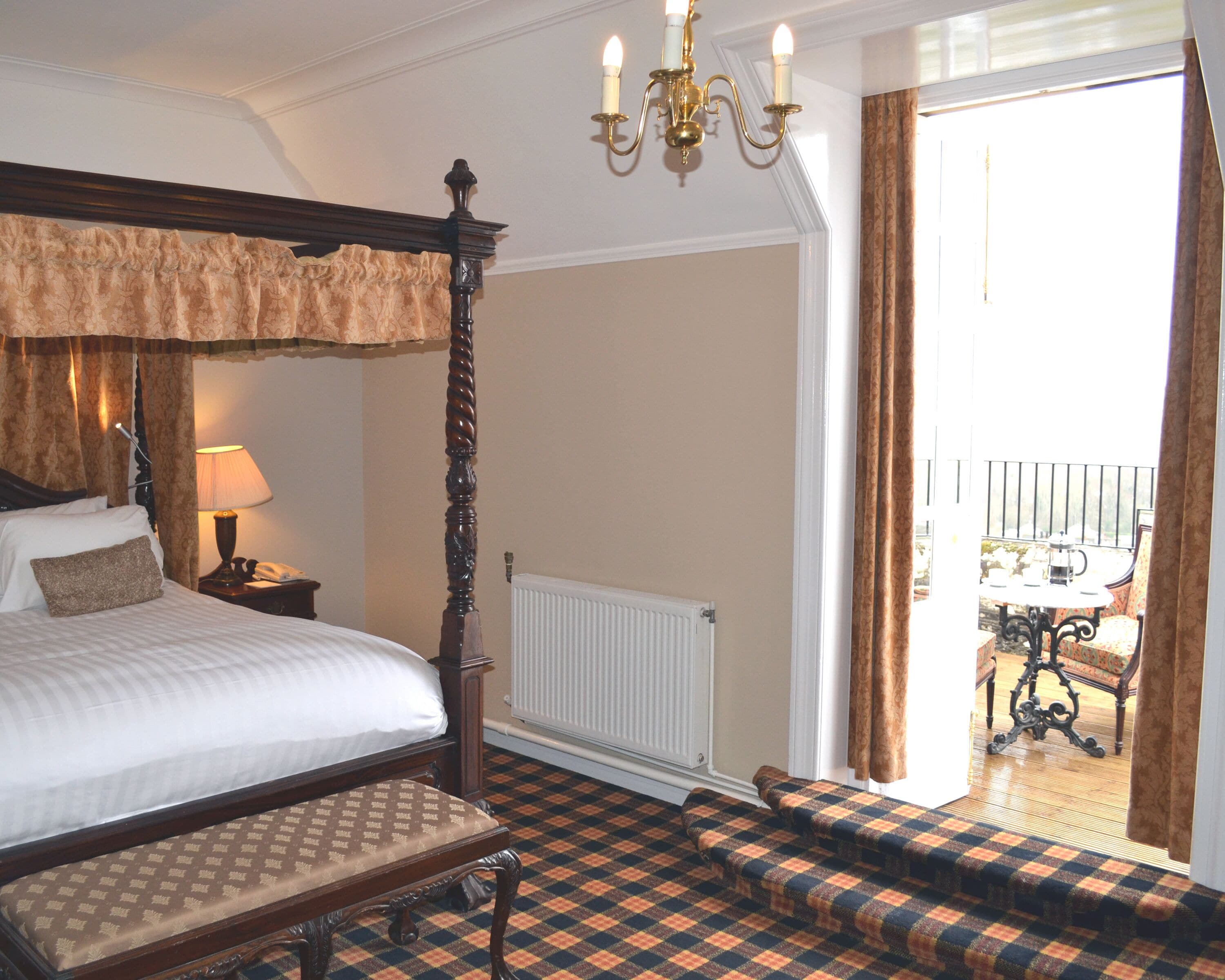 A bedroom with a four-poster bed, a bedside table with a lamp, a bench, and a checkered floor.