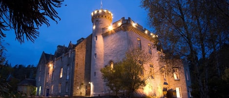 Vista frontal de la propiedad por la tarde o noche