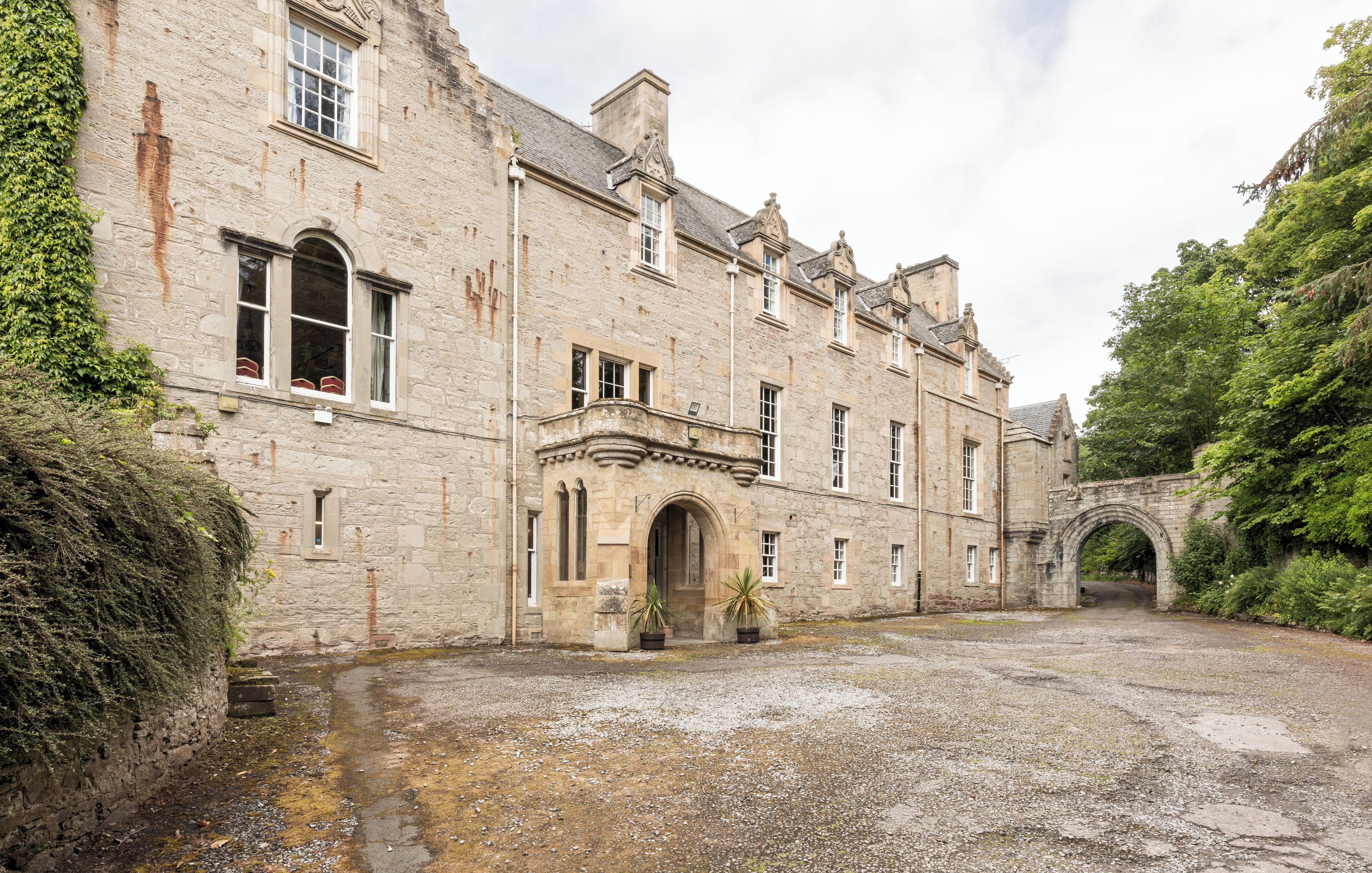 A historic stone building with arched windows and a central entrance.