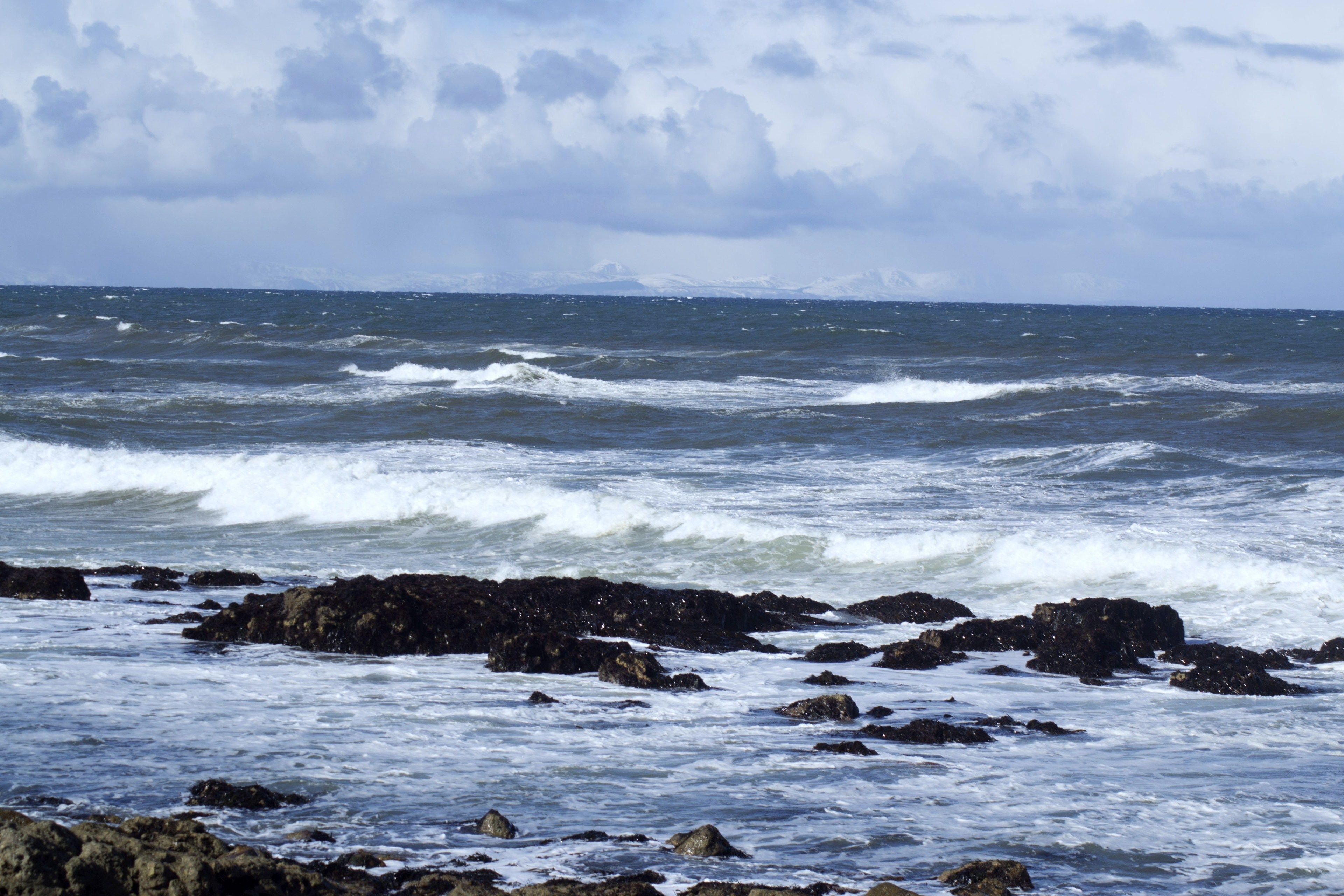 Una costa rocosa con olas rompiendo contra las rocas.