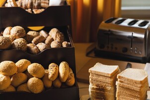Uma caixa com pães diversos e uma torradeira.