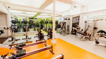 A gym with various exercise equipment, including treadmills and weight machines, arranged in a spacious layout.