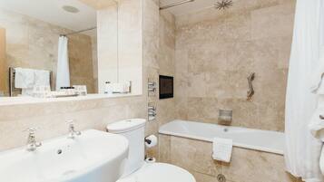 A modern bathroom with a sink, toilet, and bathtub.