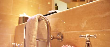 A bathroom with a towel hanging on a towel rack, a sink, and a mirror above the sink.