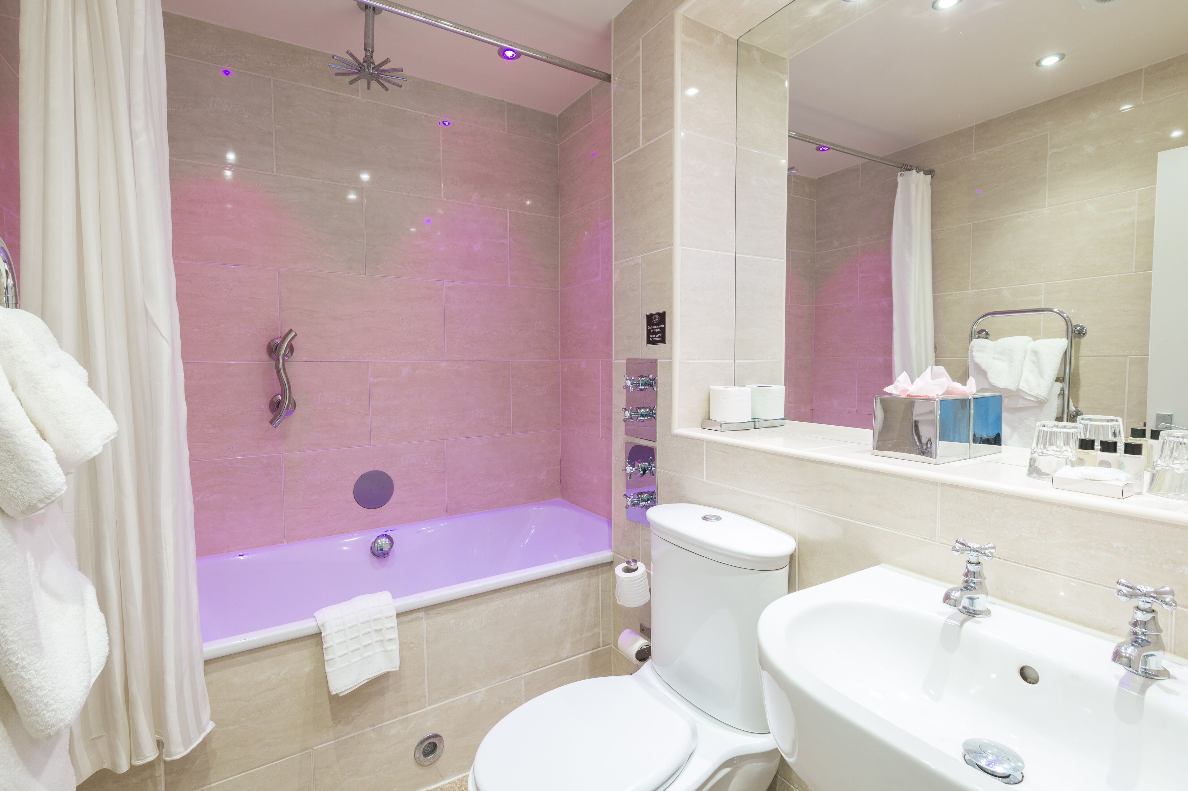 A modern bathroom with a bathtub, toilet, and sink.